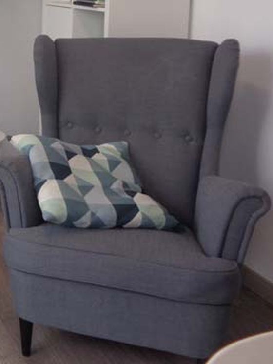 Fauteuil gris avec coussin graphique, au cabinet