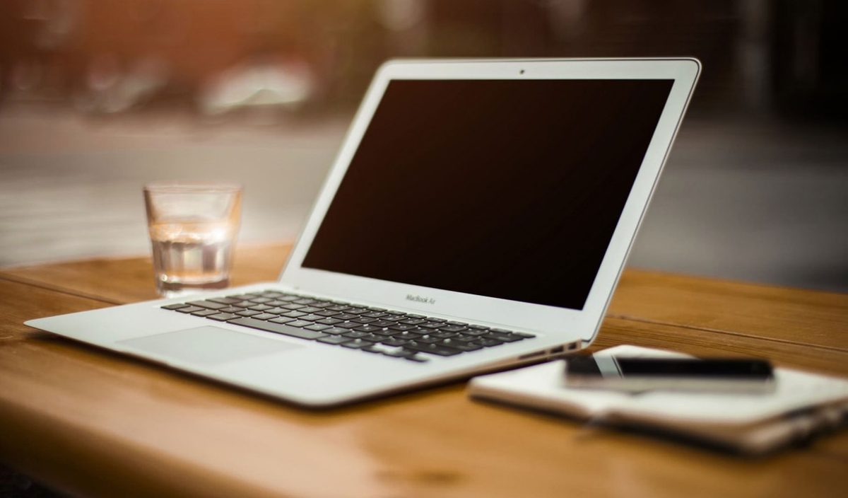 Ordinateur portable ouvert sur une table en bois — formation en ligne